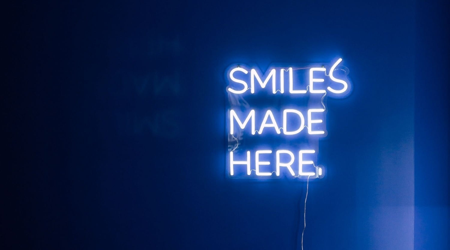 smiles made here neon sign